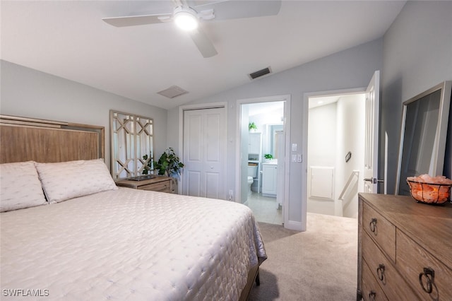 bedroom featuring light carpet, vaulted ceiling, ceiling fan, connected bathroom, and a closet