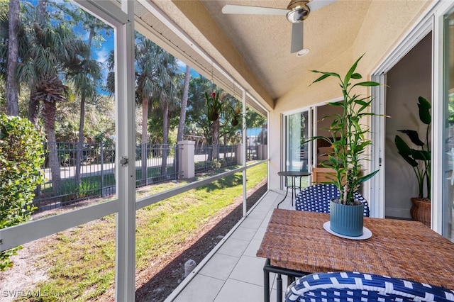 unfurnished sunroom with ceiling fan and lofted ceiling