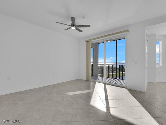 tiled spare room featuring ceiling fan