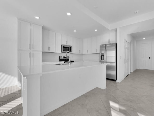 kitchen with white cabinetry, sink, stainless steel appliances, a center island with sink, and light tile patterned flooring