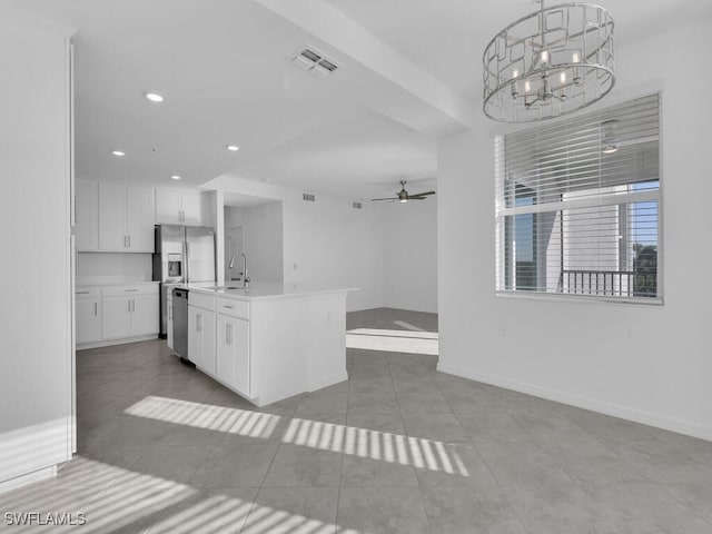 kitchen featuring sink, an island with sink, pendant lighting, white cabinets, and ceiling fan with notable chandelier