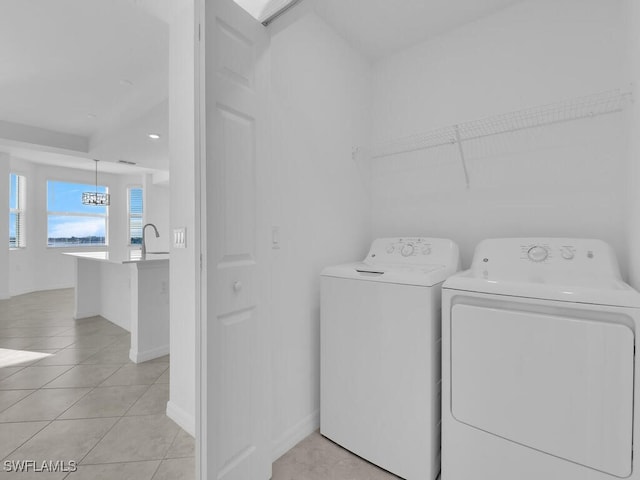 laundry room featuring washer and clothes dryer and light tile patterned floors