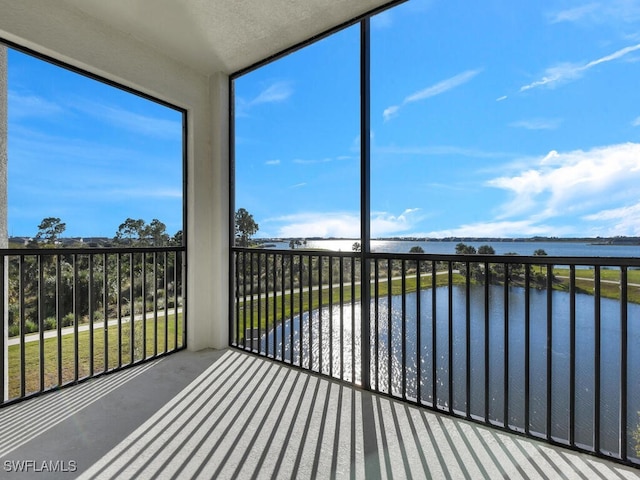 unfurnished sunroom featuring a water view