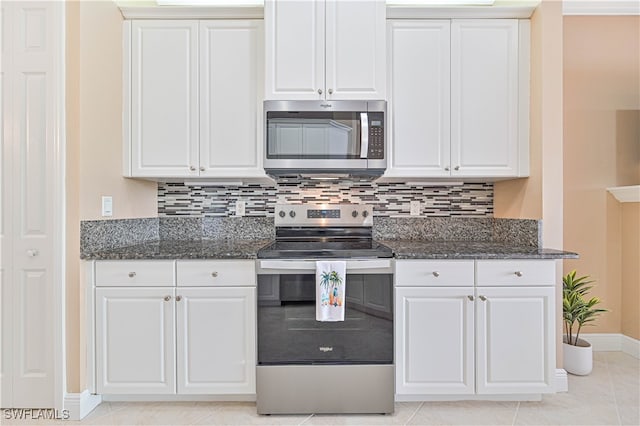 kitchen with light tile patterned floors, tasteful backsplash, dark stone counters, white cabinets, and appliances with stainless steel finishes