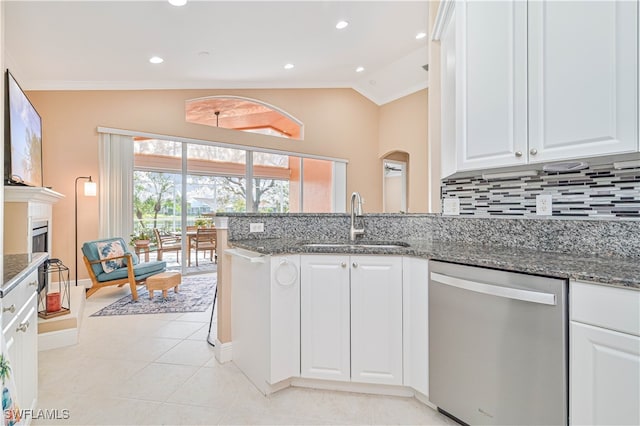 kitchen featuring white cabinetry, dishwasher, lofted ceiling, and sink