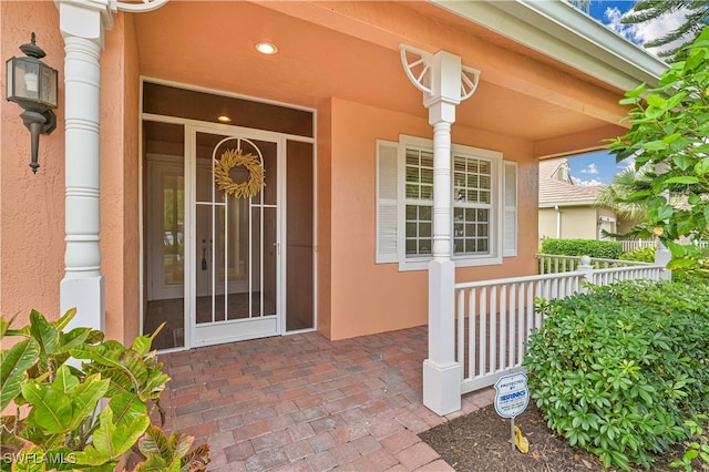 view of exterior entry featuring covered porch