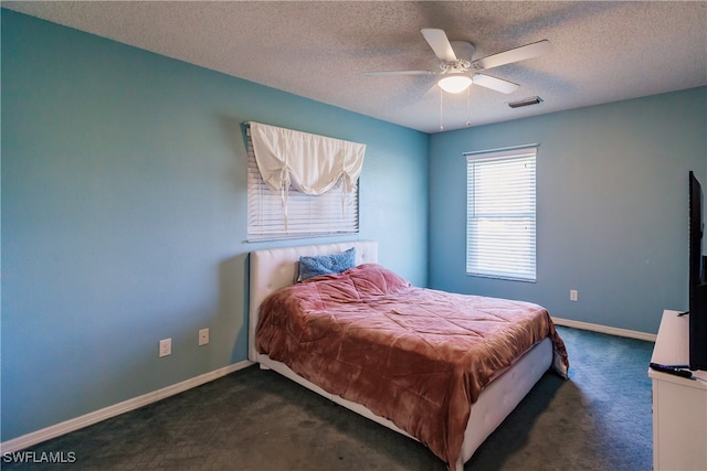 carpeted bedroom with ceiling fan and a textured ceiling