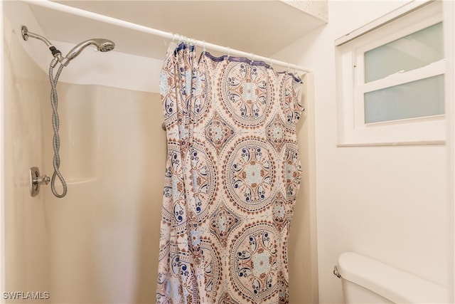 bathroom with a shower with curtain and toilet