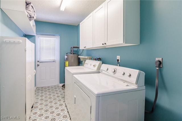 washroom featuring washer and clothes dryer, cabinets, and a textured ceiling