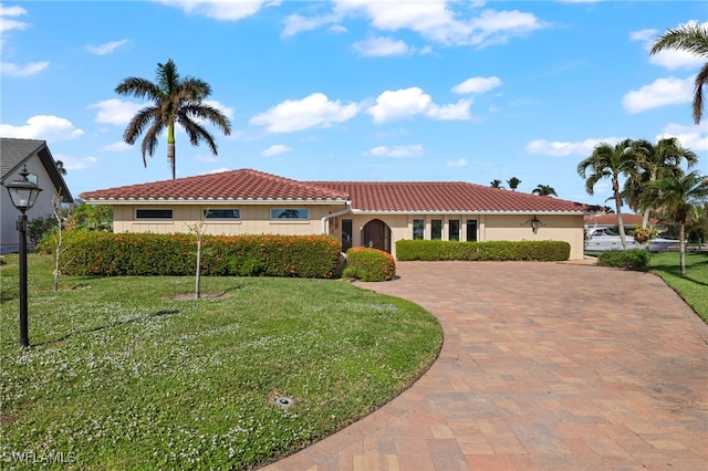 mediterranean / spanish-style home with a front lawn