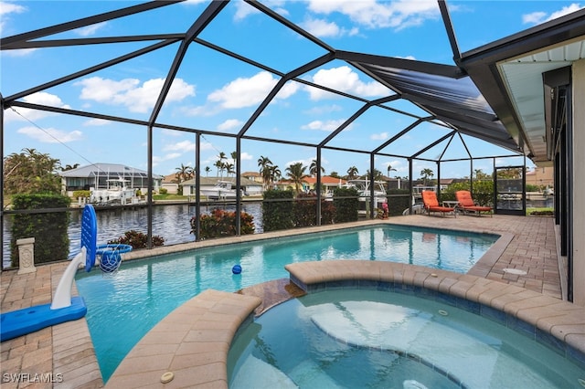 view of pool with an in ground hot tub, a patio, a water view, and glass enclosure