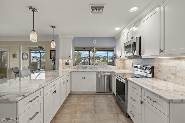 kitchen with kitchen peninsula, appliances with stainless steel finishes, a wealth of natural light, pendant lighting, and white cabinets