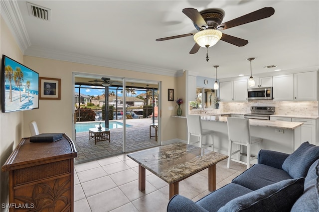 living room with ceiling fan, sink, light tile patterned flooring, and ornamental molding