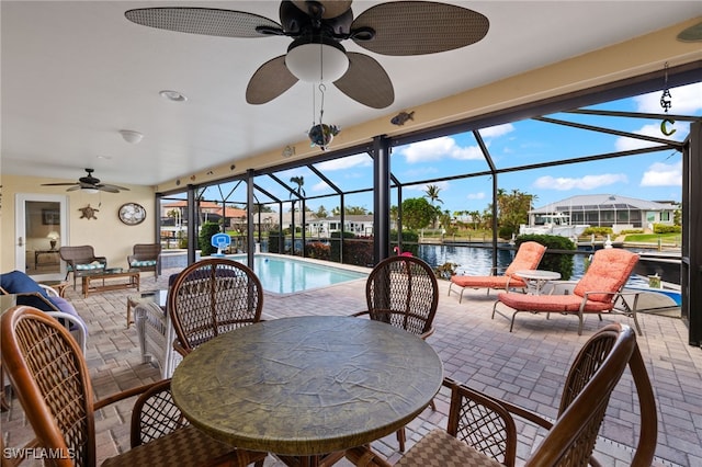 view of patio with outdoor lounge area, a water view, ceiling fan, and a lanai