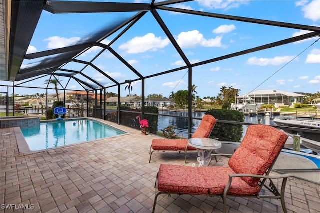 view of swimming pool with a water view, glass enclosure, and a patio area