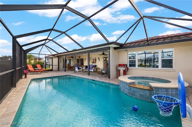 view of swimming pool featuring glass enclosure, ceiling fan, a patio area, and an in ground hot tub