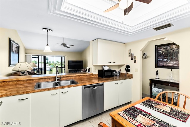 kitchen featuring dishwasher, sink, butcher block countertops, lofted ceiling, and white cabinets