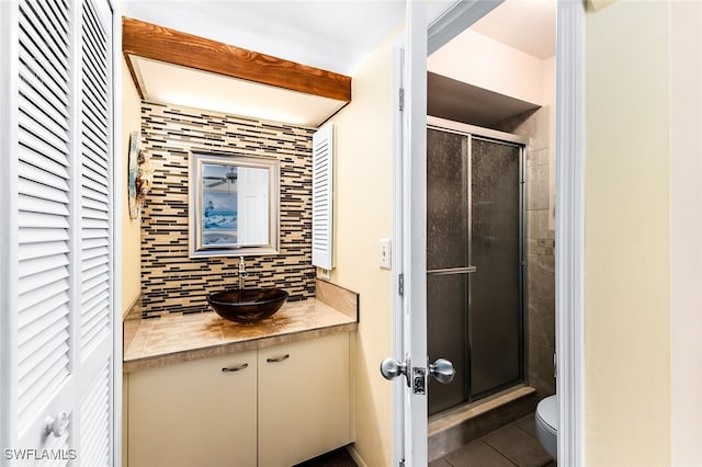 bathroom with vanity, backsplash, tile patterned floors, toilet, and walk in shower