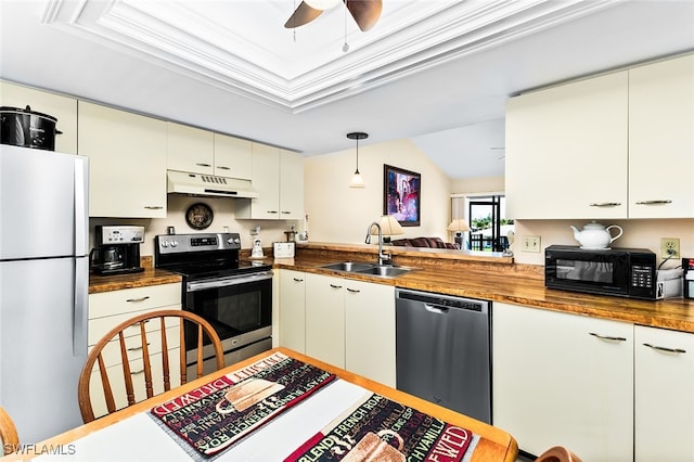 kitchen featuring butcher block counters, sink, stainless steel appliances, crown molding, and decorative light fixtures