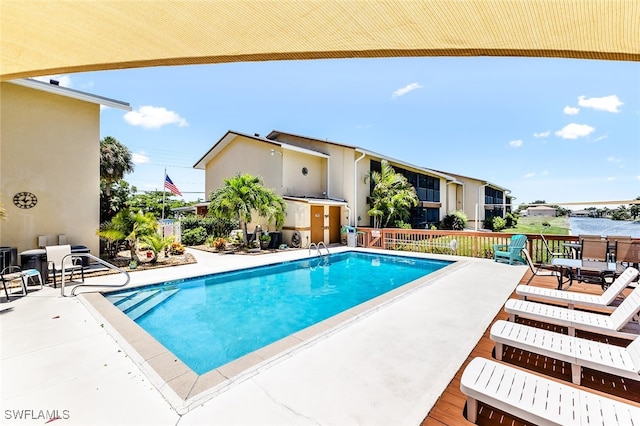 view of swimming pool with a patio and a water view