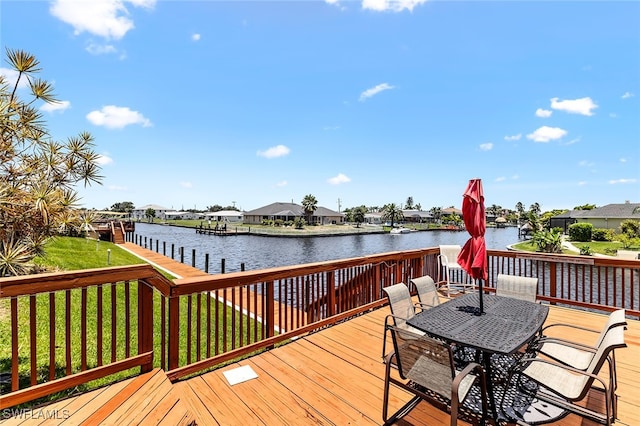 deck with a lawn and a water view