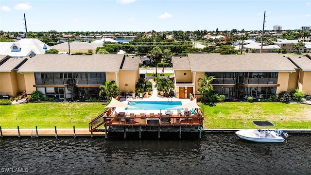 back of property featuring a water view and a lawn