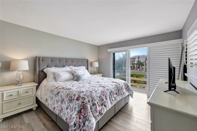 bedroom with access to exterior and light hardwood / wood-style flooring