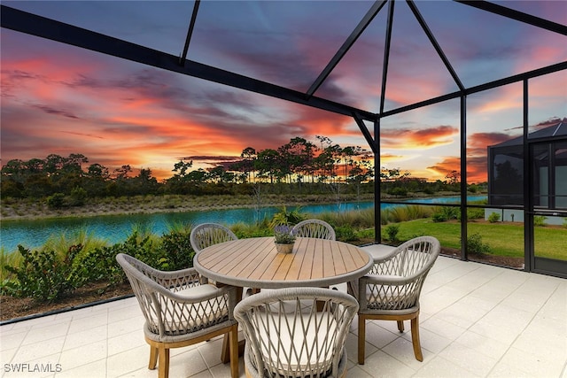 patio terrace at dusk with glass enclosure and a water view