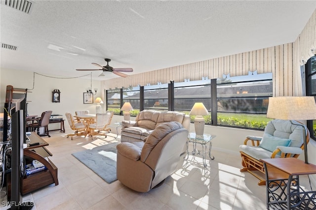 tiled living room featuring ceiling fan and a textured ceiling