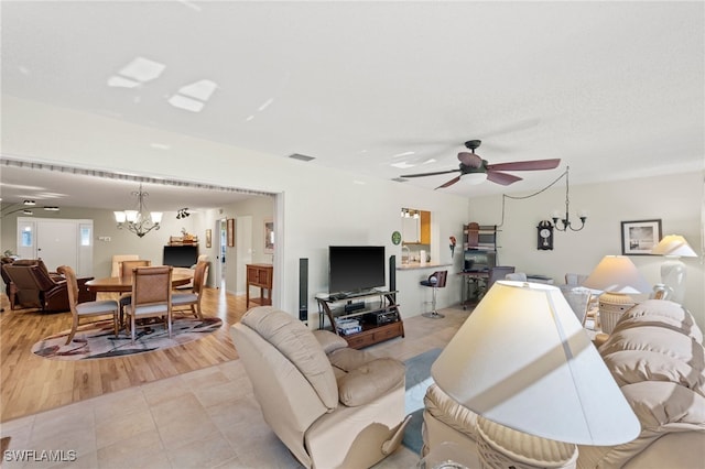 living room with ceiling fan with notable chandelier