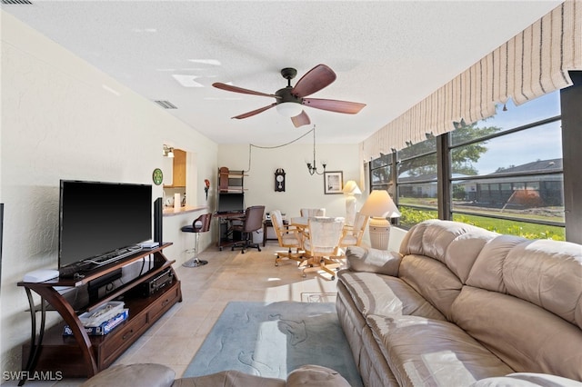 living room featuring ceiling fan and a textured ceiling