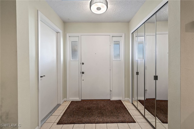 tiled entryway with a textured ceiling