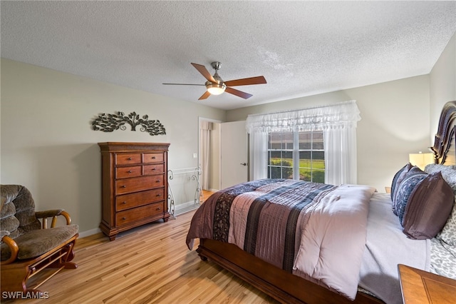 bedroom featuring ceiling fan, a textured ceiling, and light hardwood / wood-style flooring