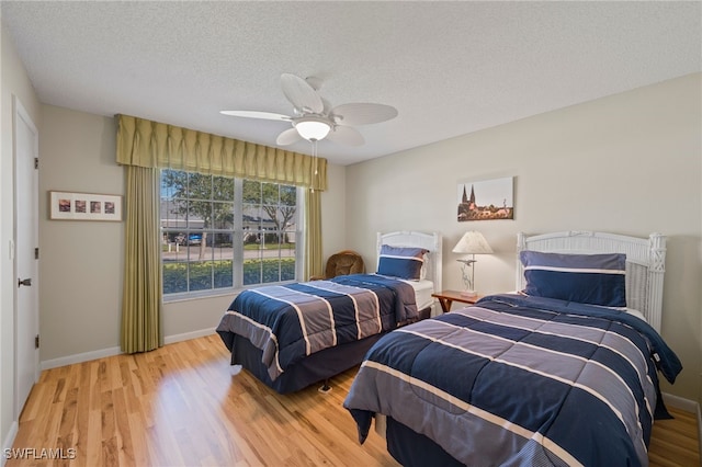 bedroom featuring a textured ceiling, ceiling fan, and hardwood / wood-style floors