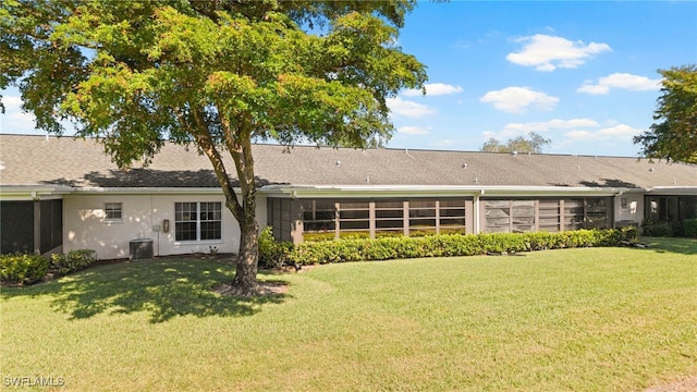 rear view of property with a yard and central air condition unit