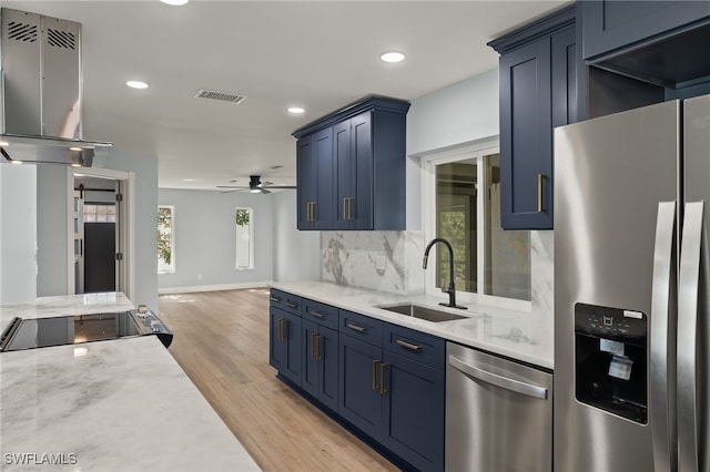 kitchen featuring ceiling fan, sink, extractor fan, appliances with stainless steel finishes, and light wood-type flooring