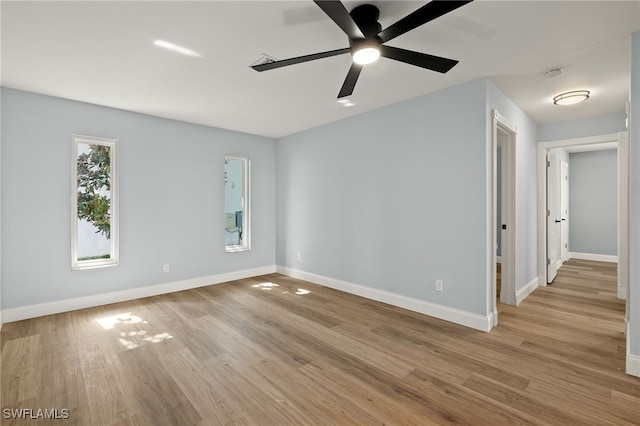 empty room with ceiling fan and light hardwood / wood-style flooring