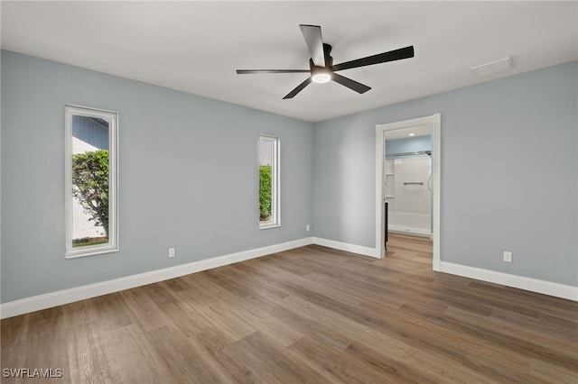 empty room with plenty of natural light, light hardwood / wood-style floors, and ceiling fan