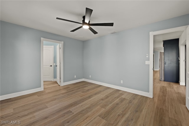 spare room with light wood-type flooring and ceiling fan