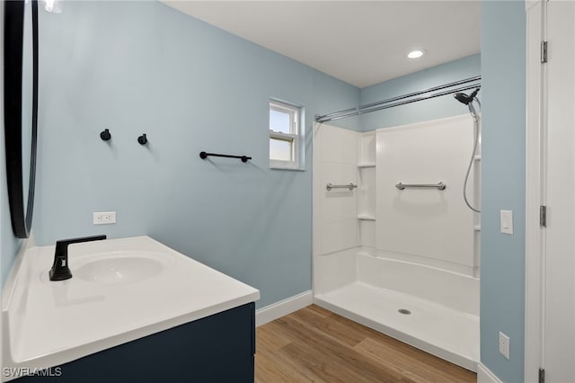 bathroom with a shower, wood-type flooring, and vanity