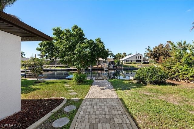 view of dock with a water view and a yard