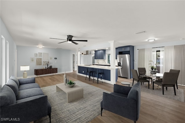 living room featuring ceiling fan and hardwood / wood-style floors