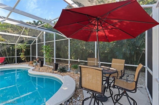 view of swimming pool featuring glass enclosure and a patio