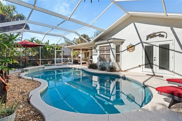 view of pool featuring glass enclosure, a patio area, and french doors