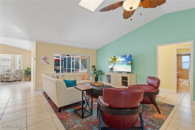 tiled living room with ceiling fan, a healthy amount of sunlight, and vaulted ceiling