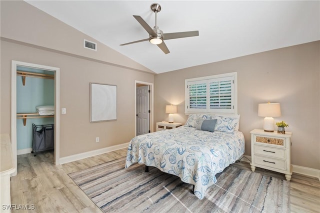 bedroom with ceiling fan, a closet, light hardwood / wood-style floors, and vaulted ceiling