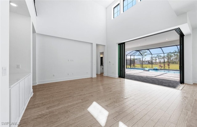 14111 Calaveras Ct, Estero, FL 33928 - unfurnished living room with a sunroom, light wood-style floors, and a high ceiling