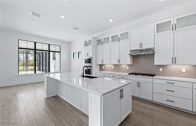 14111 Calaveras Ct, Estero, FL 33928 - kitchen featuring a sink, under cabinet range hood, gas stovetop, light countertops, and stainless steel microwave