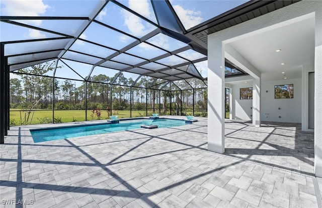 view of pool with glass enclosure and a patio area