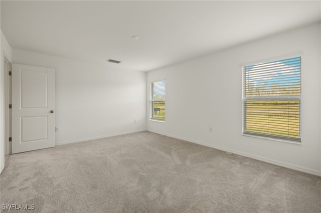 unfurnished room with plenty of natural light and light colored carpet